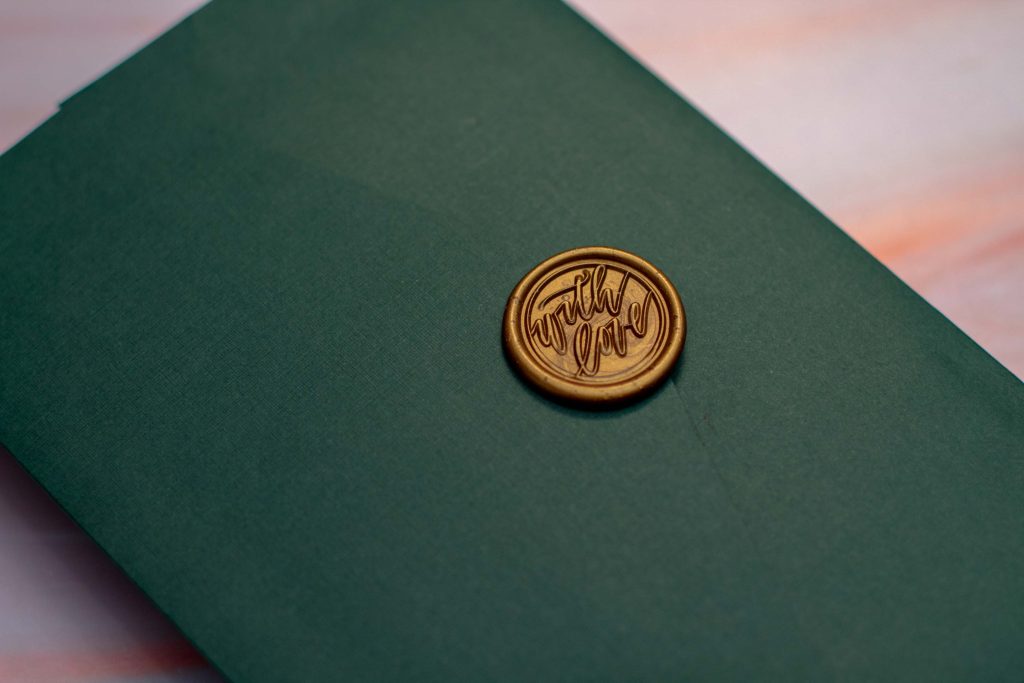 Invitación de boda verde con foil dorado con sello de lacre
